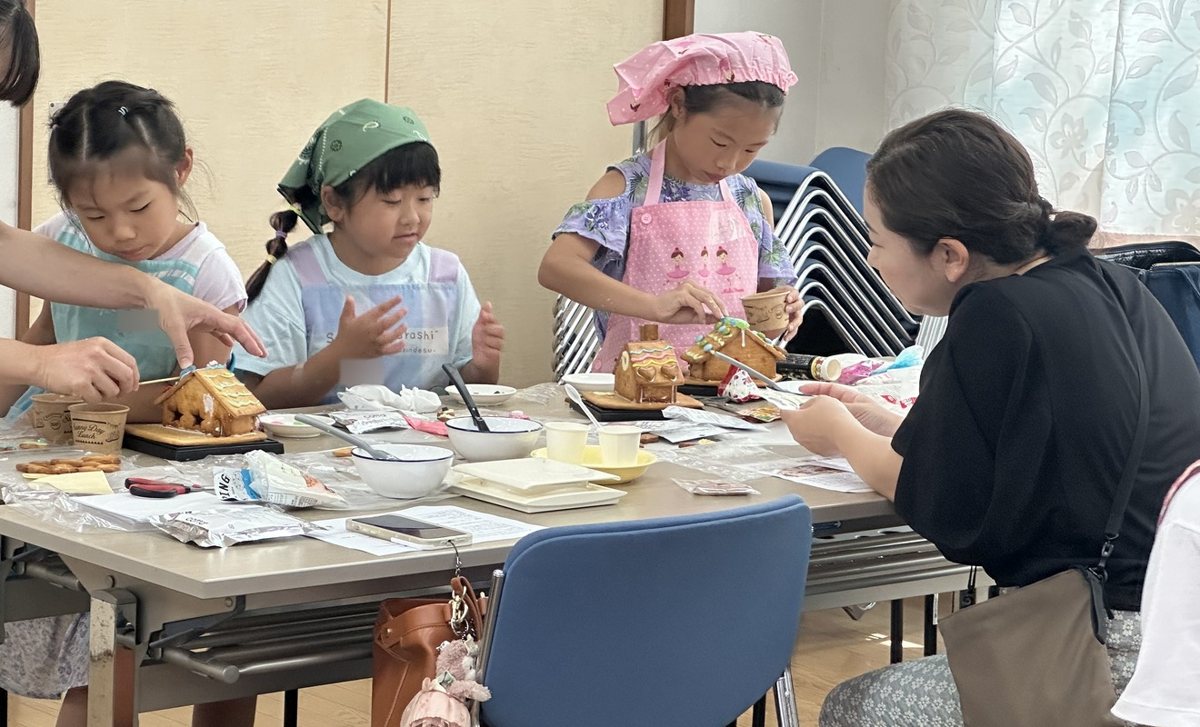 テーブルを囲み、それぞれのお菓子の家づくりに取り組む教室の風景