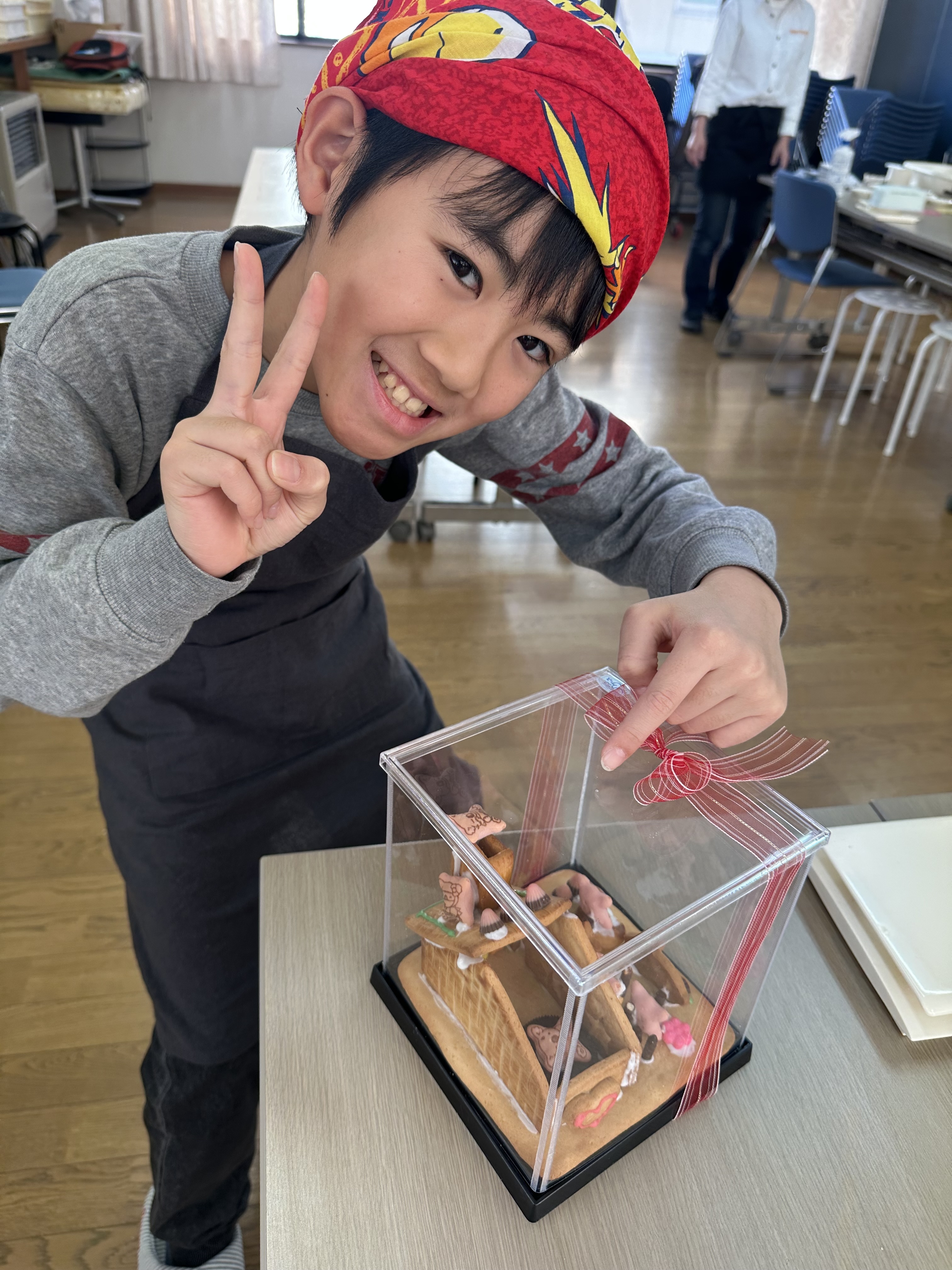 透明ケースに入った作品を見せる教室の参加者